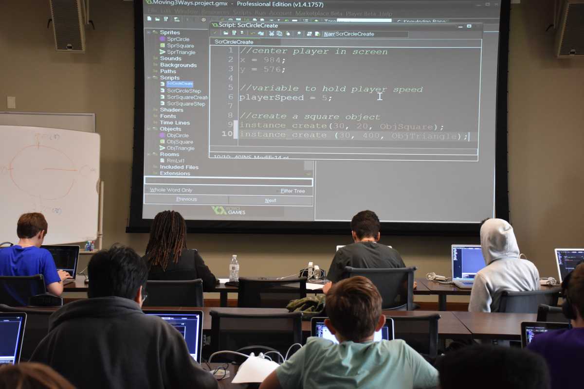 GameMaker script for sprite movement atGamecrash 2016 summer camp showing on projector screen in classroom